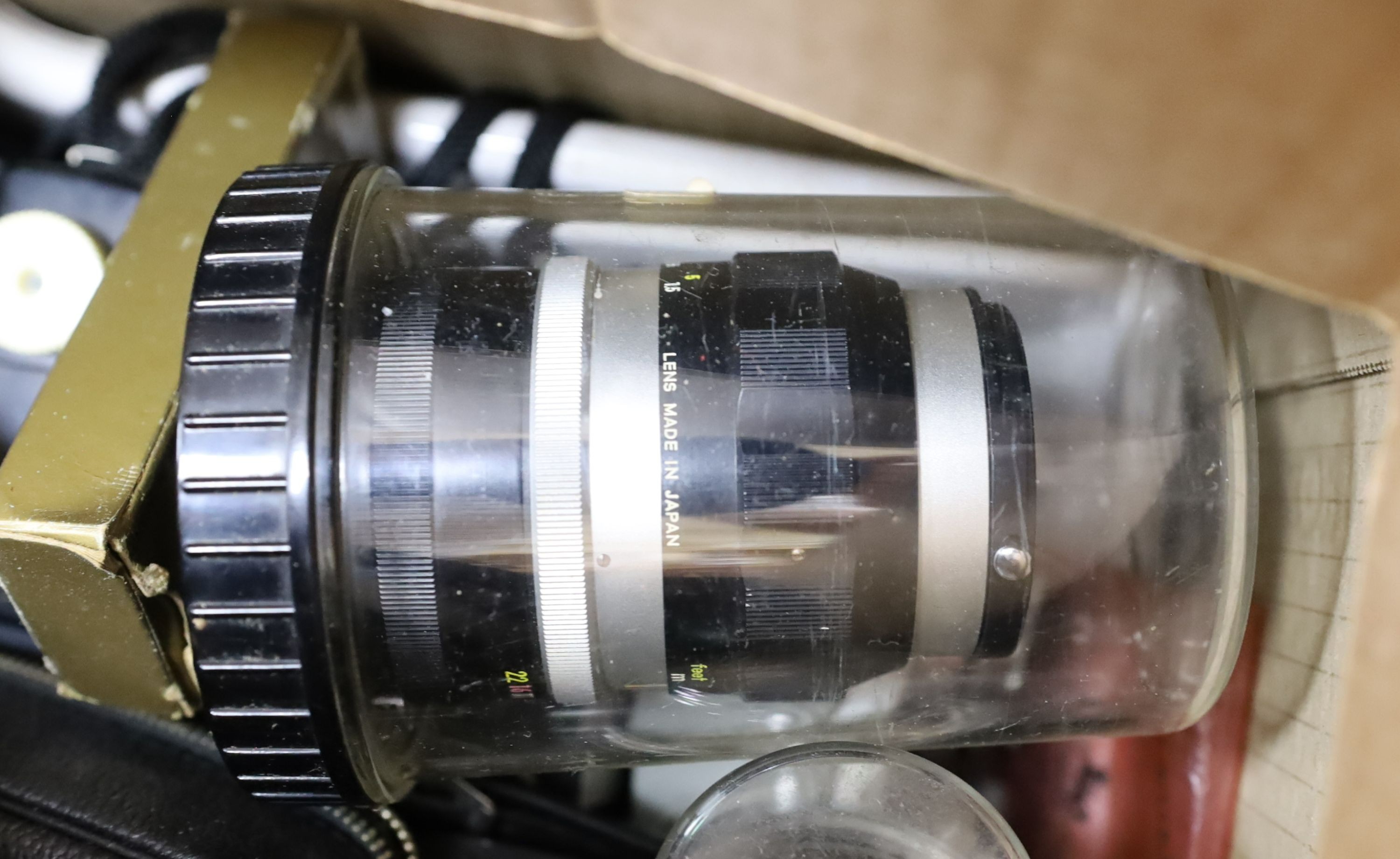 A Nikon Model F SLR camera, with additional telephoto lenses and other sundry cameras, etc.